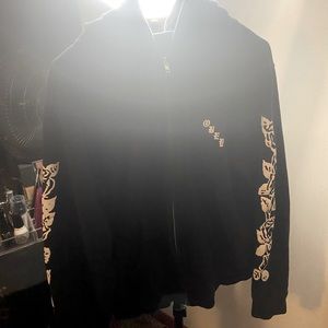 Black zip up jacket with white roses and ‘Obey’ written in Old English.